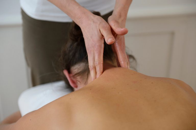 Eva Laucken massiert sanft den Nacken einer Kundin in der Massagepraxis Laucken.